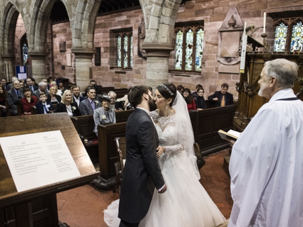 bride and groom first kiss in church, cheshire wedding photographer