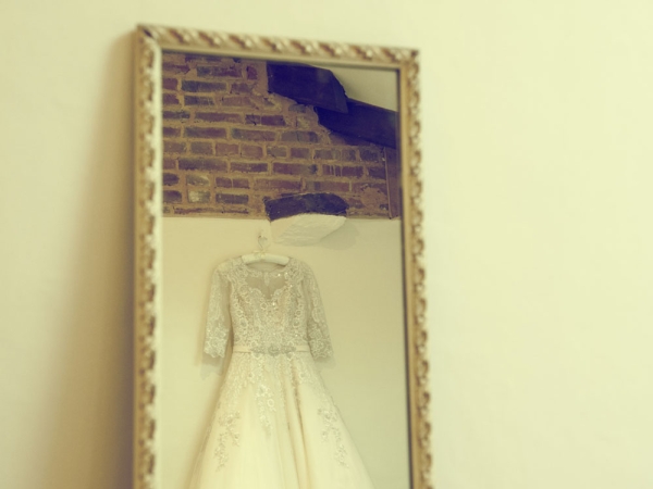 brides dress hanging up in mirror, staffordshire wedding photographer, heath house weddings