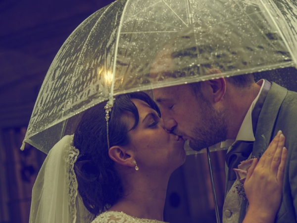 bride and groom kiss under an umbrella in the rain, staffordshire wedding photographer, heath house weddings