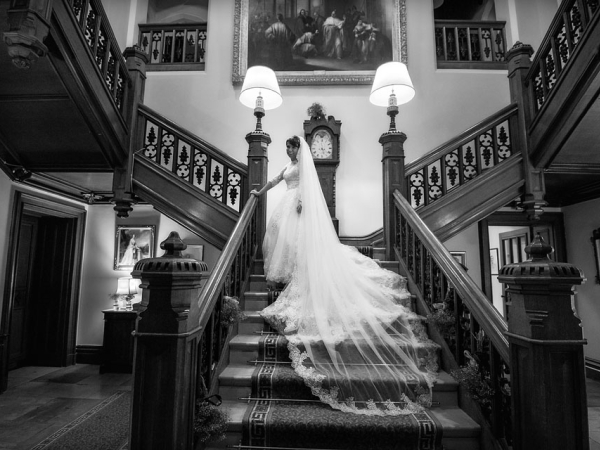 bride on a big hotel staircase, staffordshire wedding photographer, heath house weddings