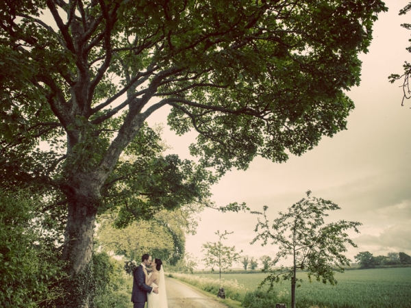 bride and groom kiss country lane, gloucestershire wedding photographer, cripps barn