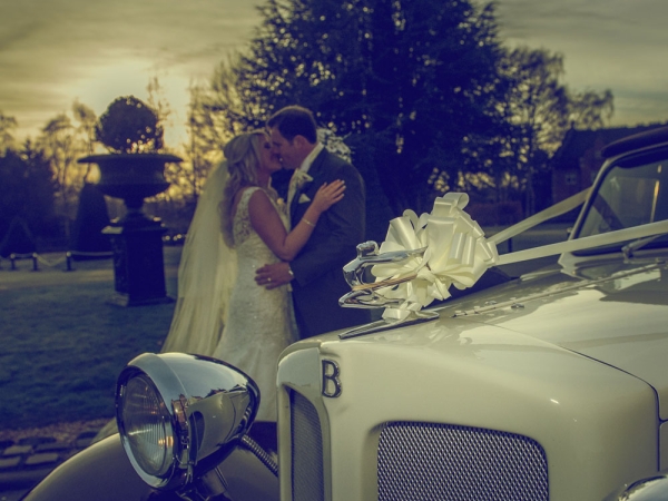 bride and groom kissing, bentley wedding car, cheshire wedding photographer, crewe hall