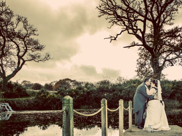 bride and groom black and white, trees across a lake, wedding photographer in wales