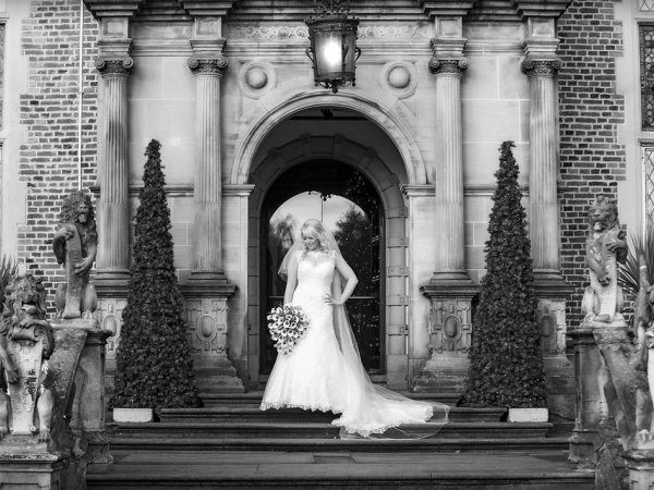 bride standing in archway, black and white, cheshire wedding photographer, crewe hall