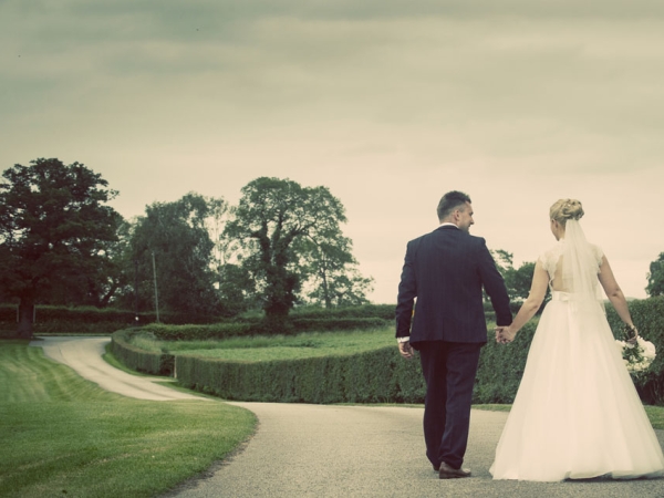 bride and groom walking hand in hand, cheshire wedding photographer, sandhole oak barn