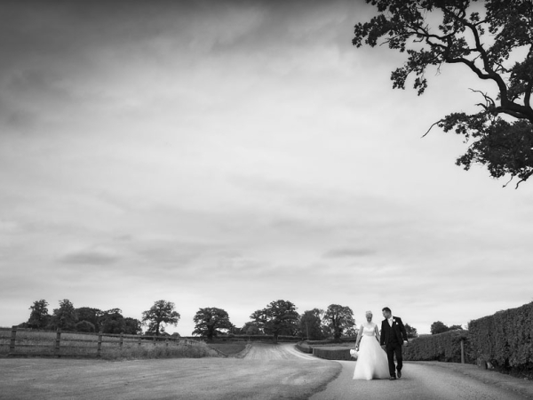 black and white, bride and groom walking hand in hand, cheshire wedding photographer, sandhole oak barn